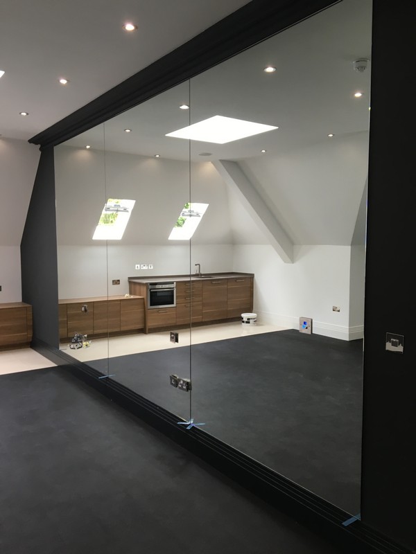 Frameless glass partition in loft conversion by East Ham glaziers