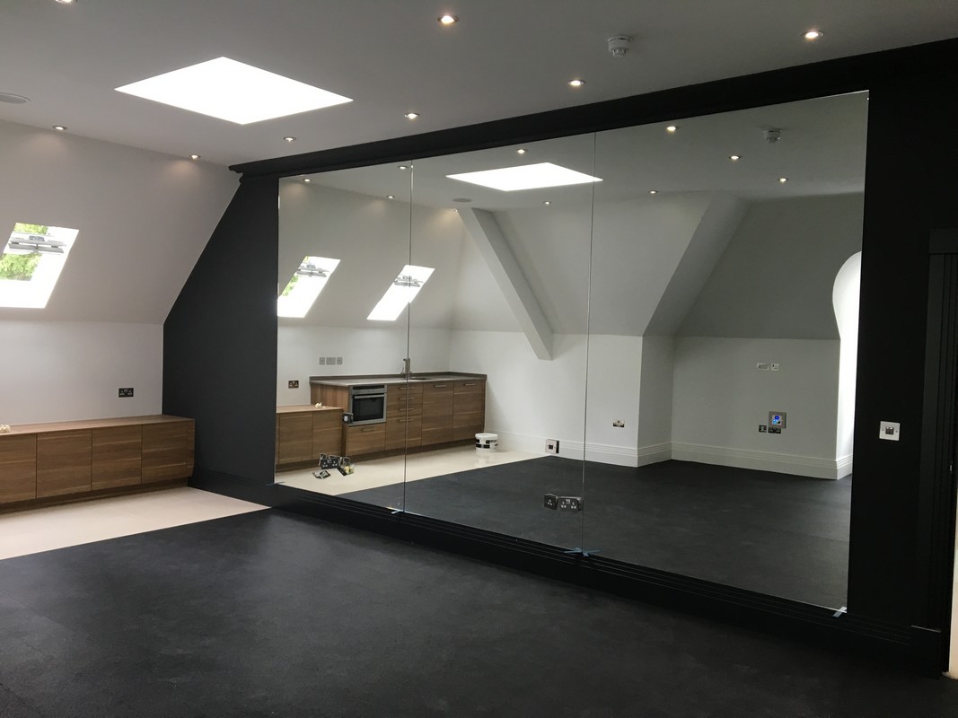 Frameless glass wall dividing loft conversion in East Ham